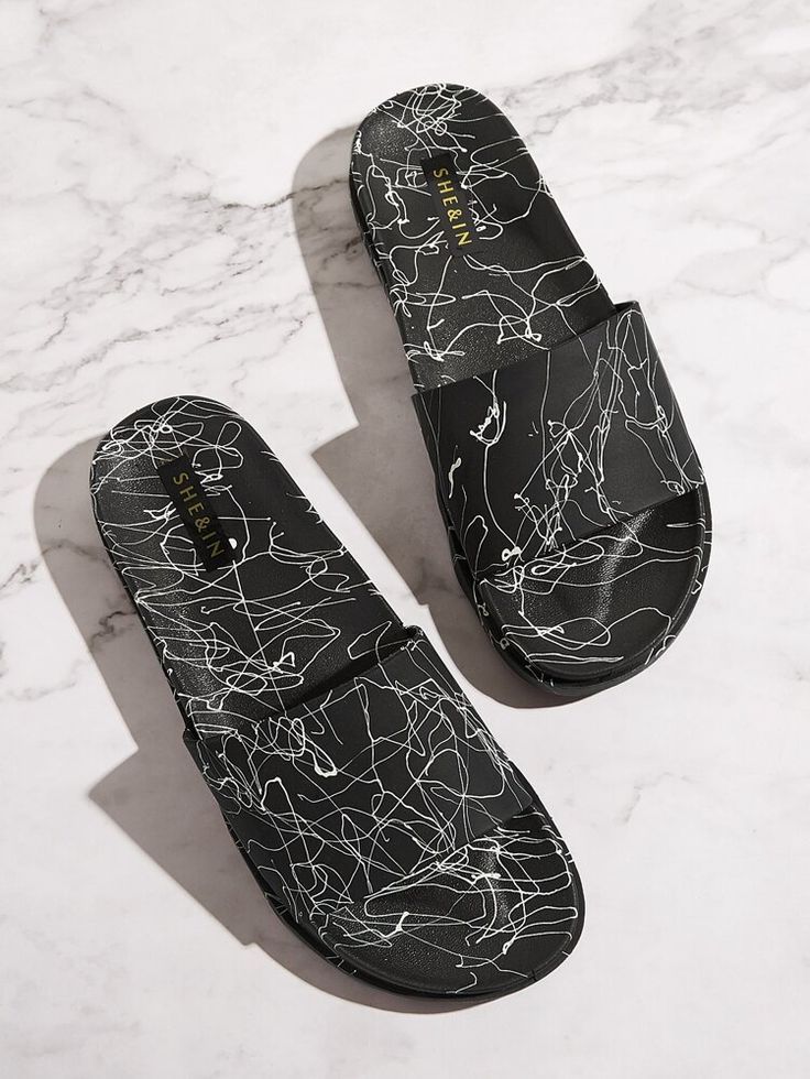 Black comfort slide sandals with an abstract white line pattern and wide slip-on strap.