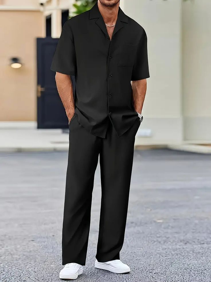 Men's black co-ord set featuring a relaxed-fit short-sleeve button-up shirt with matching straight-leg trousers, styled with white sneakers for a sleek smart-casual look.